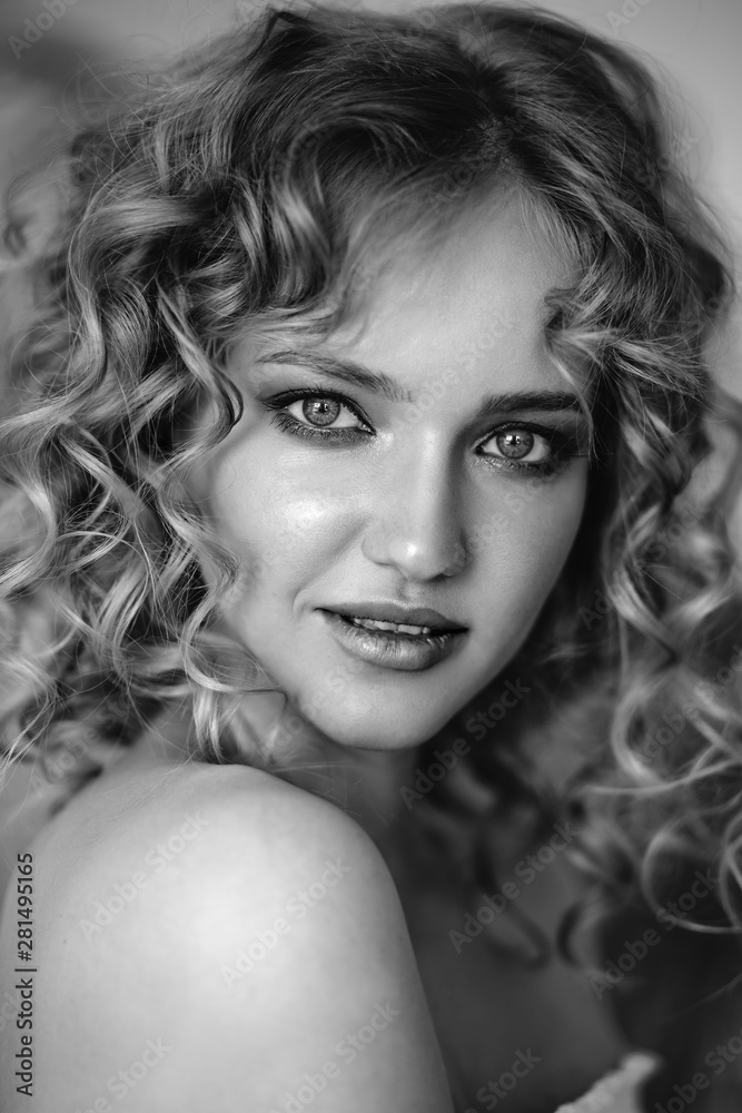 Fototapeta premium Close up portrait of blonde charming young woman with curly hair and natural makeup. Sunny morning, spa and care