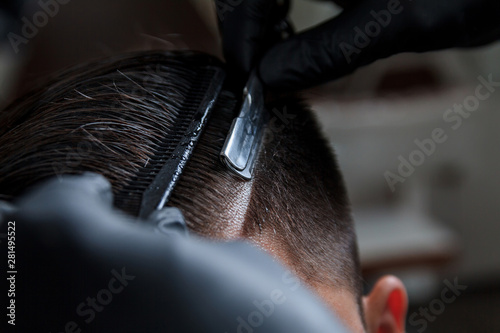 Hairdresser makes hairstyle a man. Hairdresser at work. Stylish men's hairstyle.