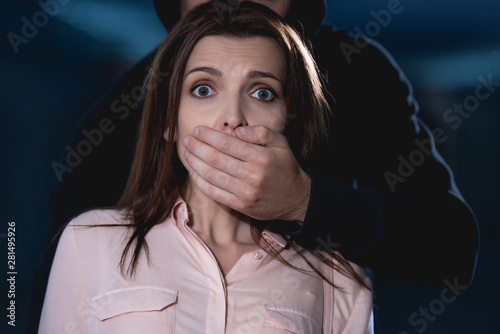 Foto thief strangling frightened woman looking at camera