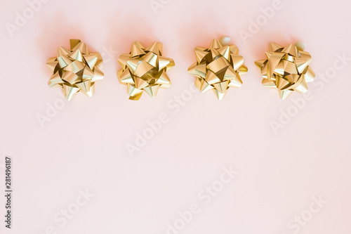 Gold ribbon with bow on pastel background.Gift box wrapping, wrapping materials. Christmas presents preparation.Copy space