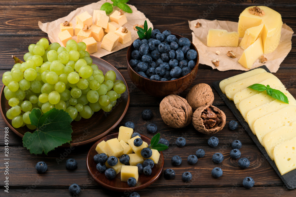 cheese, grapes and blueberries on a wooden background