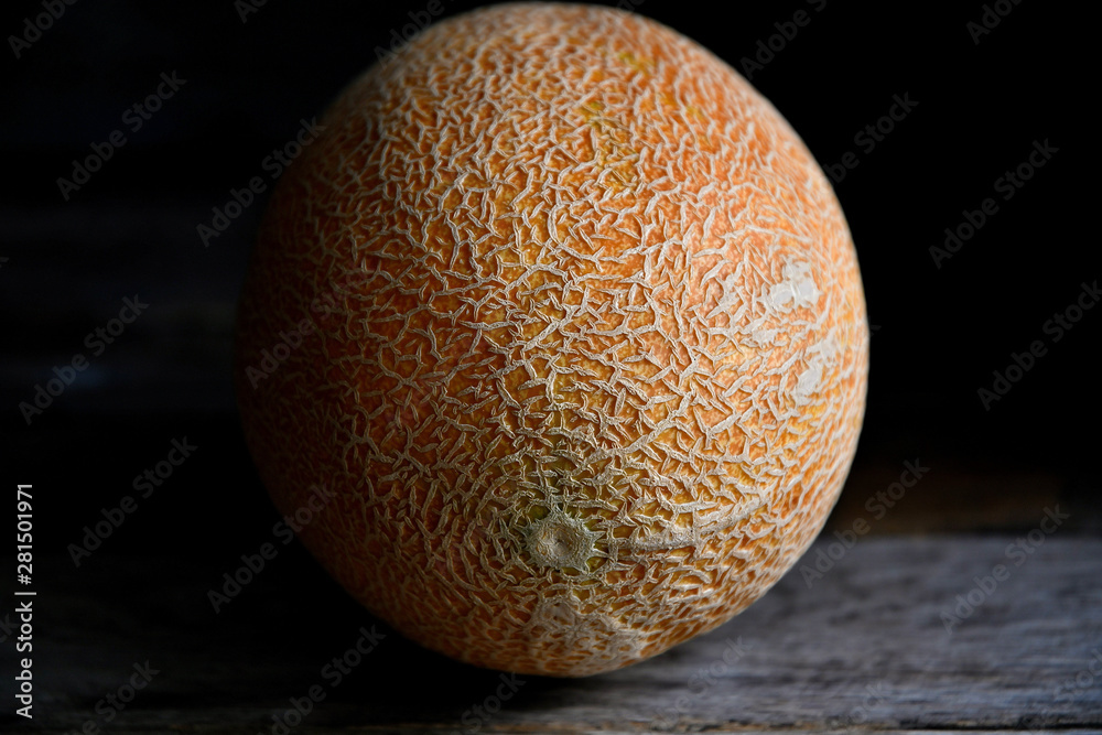 Whole fruit of a melon with a knife on an old rustic table. Whole fruit of a melon with a knife on an old rustic table.