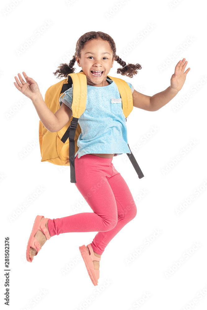Jumping little African-American schoolgirl on white background
