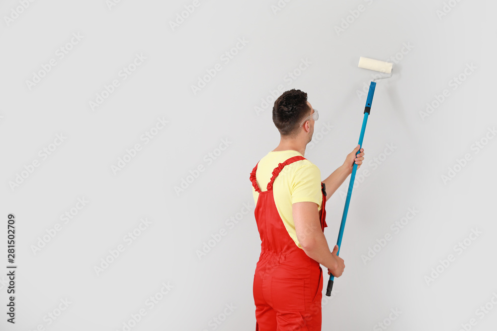 Male decorator painting light wall Male decorator painting light wall