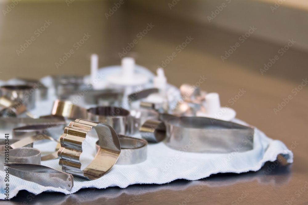Many metal molds for cutting cookies of different shapes on a light background. Many metal molds for cutting cookies of different shapes on a light background.