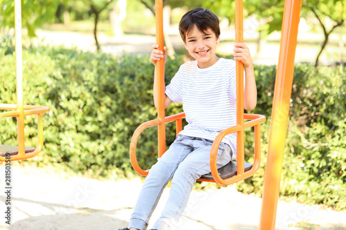 Cute little boy on swings in park
