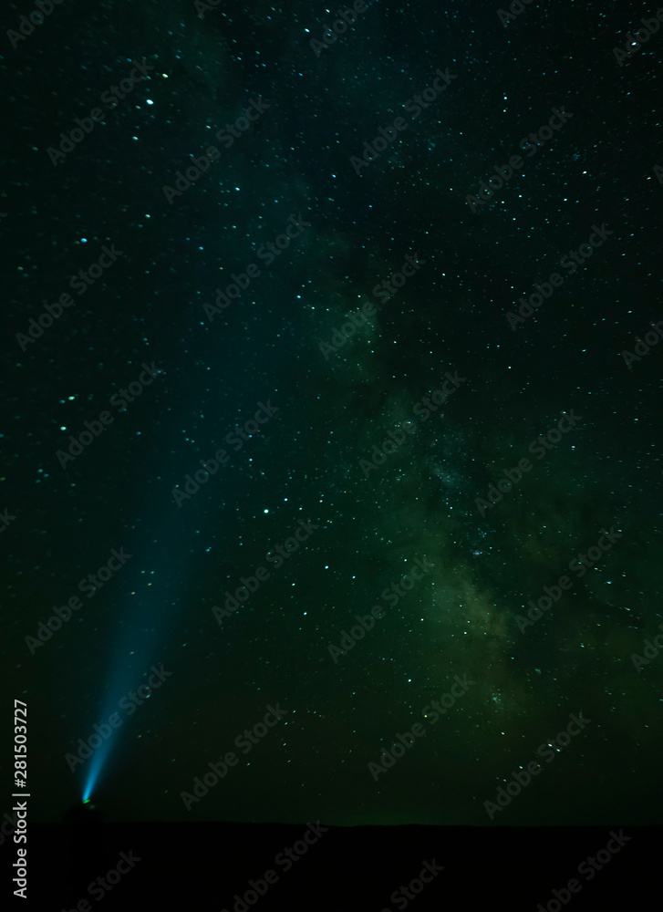 Fototapeta premium Torch light pointing to the Milky Way - Gobi Desert, Mongolia