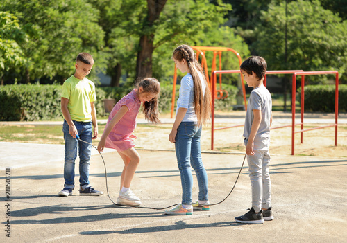 Cute little children jumping rope on playground