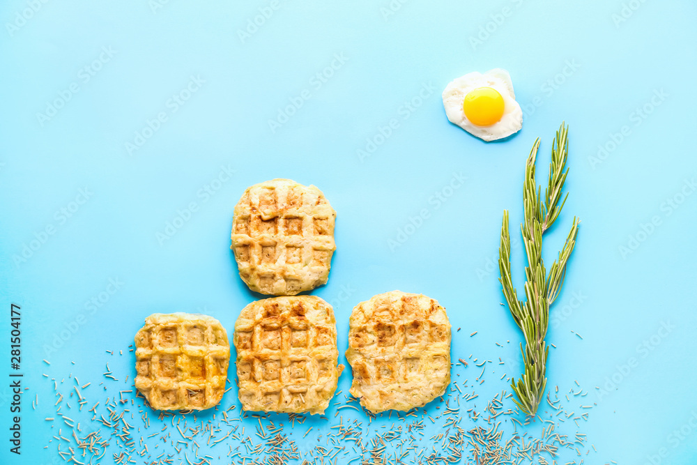 Creative composition with waffles, fried egg and spices on color background