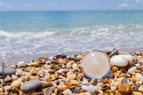 Glass round ball lying on the beach on small stones