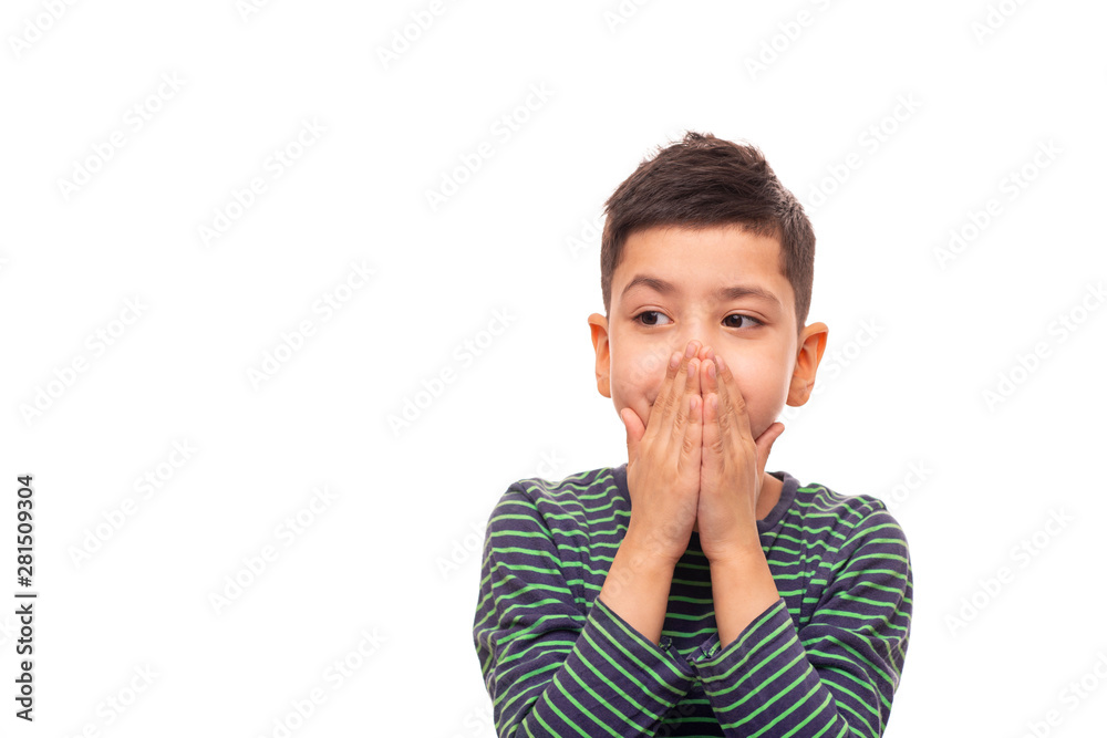 A boy is embarrassed about something and with his palms hid his mouth restraining his emotions A boy is embarrassed about something and with his palms hid his mouth restraining his emotions