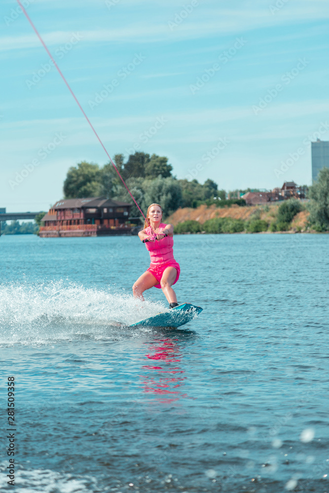 Fit Caucasian attractive wakeboarder in a pink outfit looking straight ahead Fit Caucasian attractive wakeboarder in a pink outfit looking straight ahead