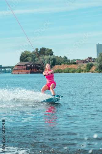 Fit Caucasian attractive wakeboarder in a pink outfit looking straight ahead