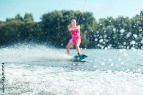 Fototapeta Naklejka Na Ścianę i Meble -  Girl wakeboarding on a local river in summer
