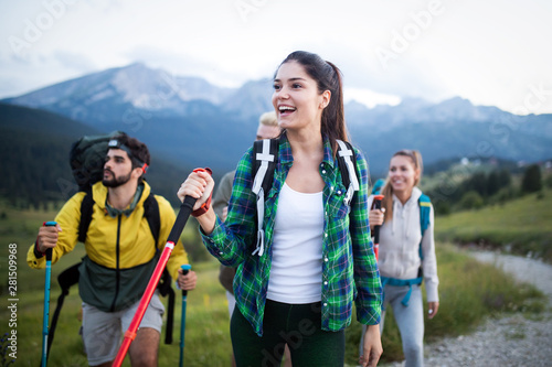 Group of friends on a mountain. Men and women climbing rocks.