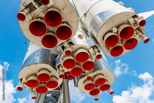 Red painted nozzles of jet engines of soviet space rocket Vostok in VDNH park in Moscow closeup at sunny summer day against blue sky with white clouds © Vladimir Zhupanenko