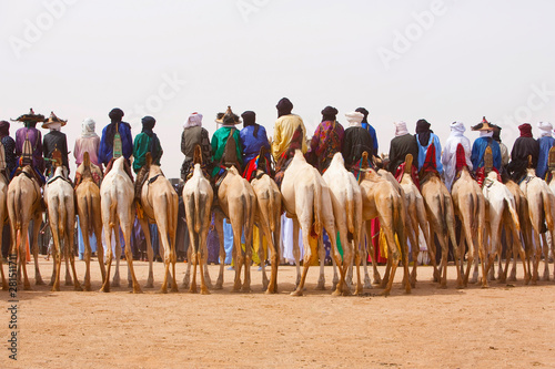 Rear view of men riding camels in desert