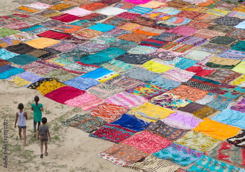 High angle view of children walking in field beside colorful clothes photo