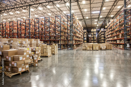Cardboard boxes on pallets in distribution warehouse photo