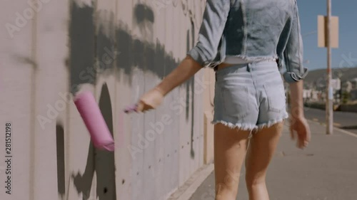 sexy woman painting wall with pink paint walking in city street confident female artist enjoying creative expression with urban graffiti art with rgb glitch