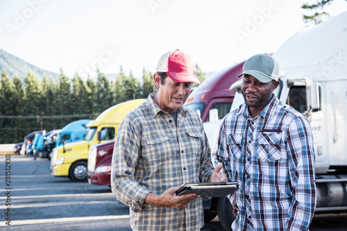 Truck drivers using digital tablet at truck stop photo