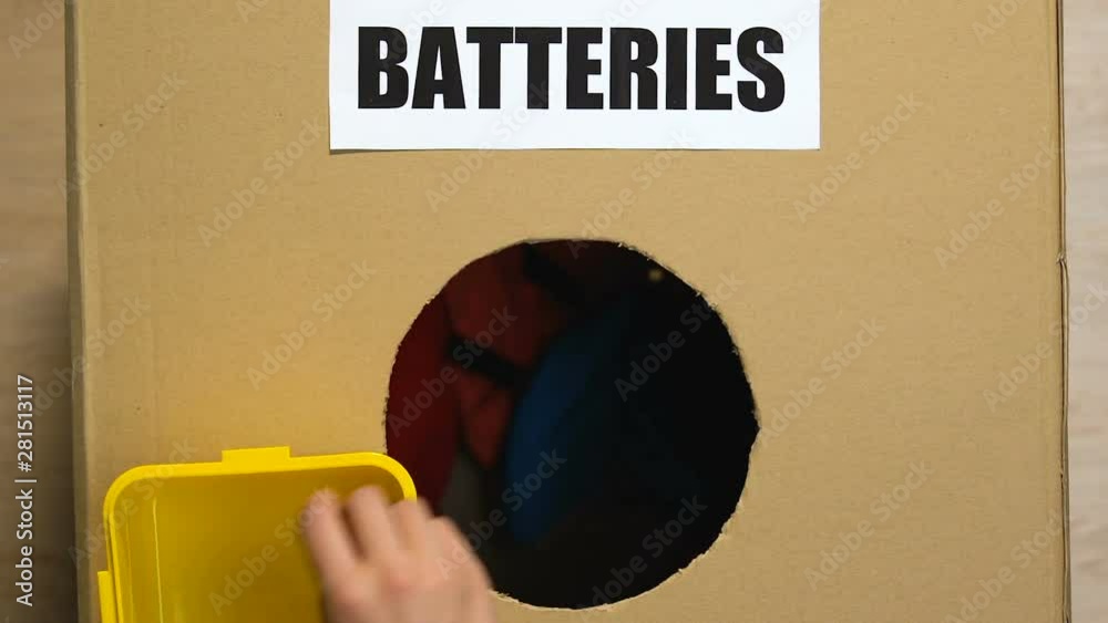 Hand throwing batteries in box with clothes on bottom, inappropriate