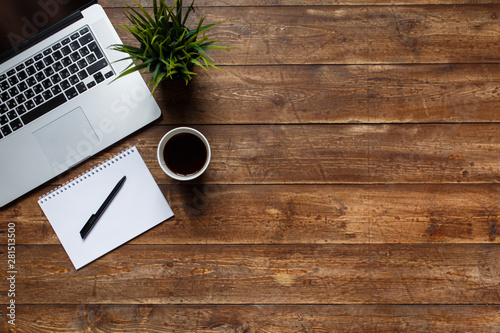 work space of a businessman. view from above . coffee black note and laptop on the desktop with black note. laptop on wooden background