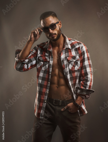 Handsome Male Model With Sunglasses Wearing Unbuttoned Shirt Exposing His Muscular Torso