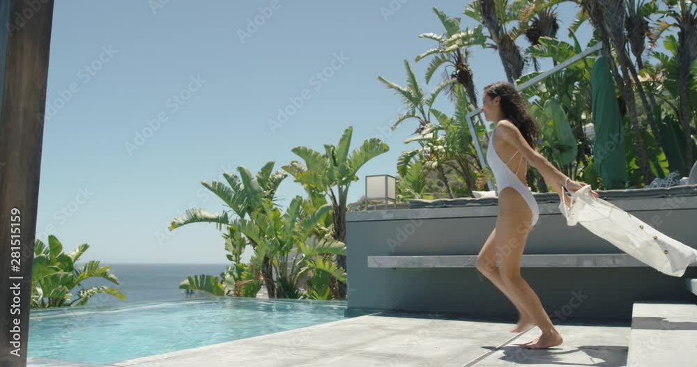 happy woman jumping in swimming pool at luxury hotel enjoying swim at tropical resort with ocean view having fun summer vacation on warm sunny day mediterranean travel 4k