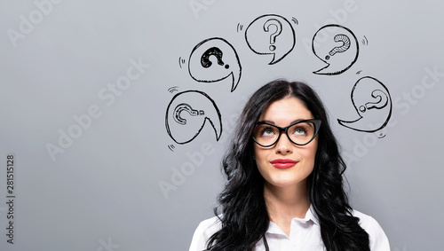 Question marks with speech bubbles with young businesswoman in a thoughtful face photo