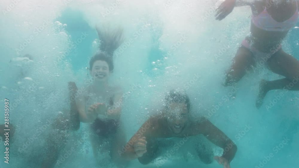 friends jumping in swimming pool underwater having fun celebrating summer vacation together group of teenagers enjoying pool party spring break celebration 4k