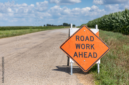 Road work ahead sign on barricade on rural country asphalt road