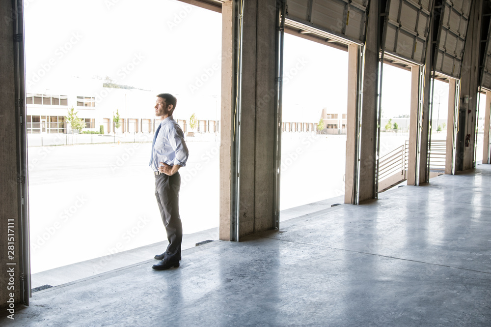 Side view of architect standing at entrance in warehouse