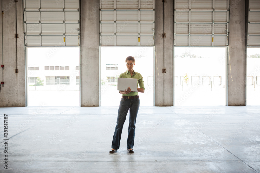 Architect using laptop while standing in warehouse Architect using laptop while standing in warehouse