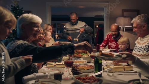 family christmas dinner man cutting turkey serving delicious meal at festive celebration people sitting at table enjoying delicious feast celebrating holiday at home 4k footage