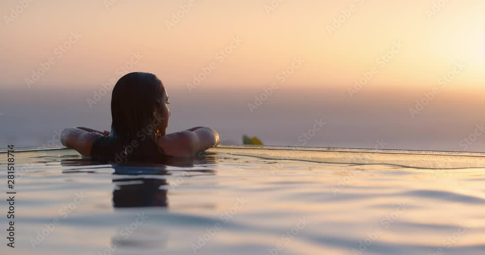 travel woman swimming in pool at luxury hotel spa with beautiful sunset view of ocean mediterranean travel holiday resort relaxing lifestyle freedom 4k
