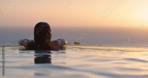travel woman swimming in pool at luxury hotel spa with beautiful sunset view of ocean mediterranean travel holiday resort relaxing lifestyle freedom 4k
