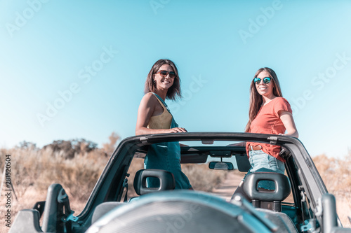 beautiful girls and young people traveling with the jeep car