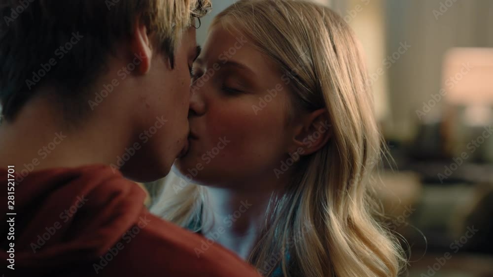 happy teenage couple first kiss girl kissing boyfriend at home after romantic evening date together 4k