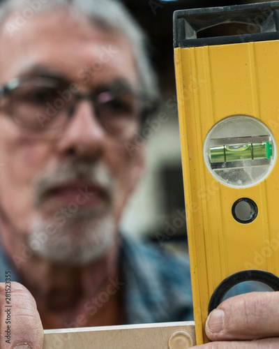 Close up of carpenter measuring wood with spirit level