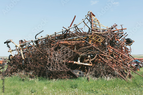 Pile of discarded farming equipment in rural landfill