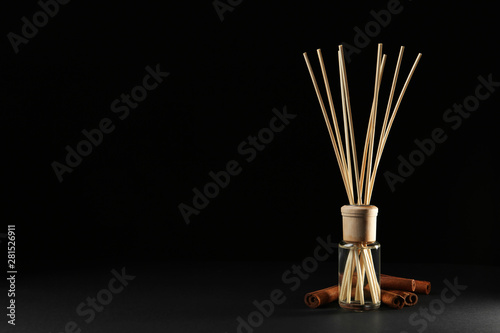 Reed air freshener with anise and cinnamon on black background, space for text