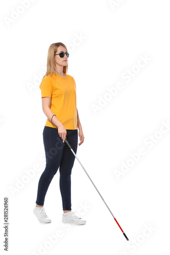 Blind woman in dark glasses with walking cane on white background