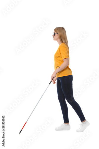 Blind woman in dark glasses with walking cane on white background
