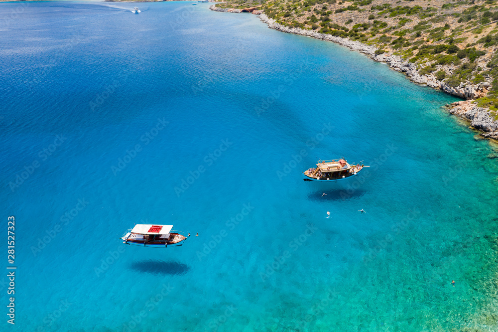 Aerial view of traditional Greek boats over a crystal clear, warm ocean on the island of Crete
