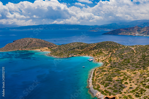 Aerial drone view of the dry, yellow coastline of the Greek island of Crete in the middle of summer