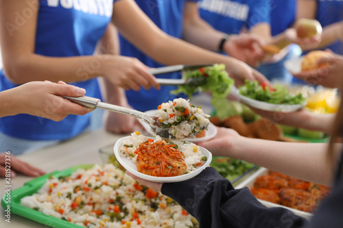 Volunteers serving food to poor people, closeup