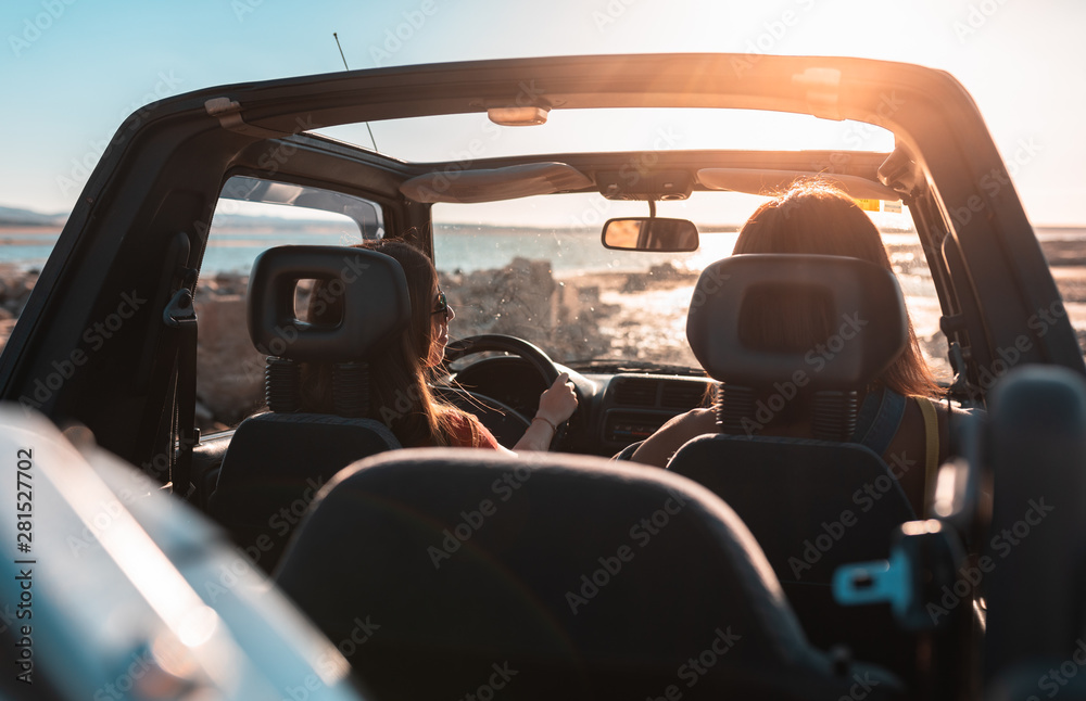 beautiful girls and young people traveling with the jeep car