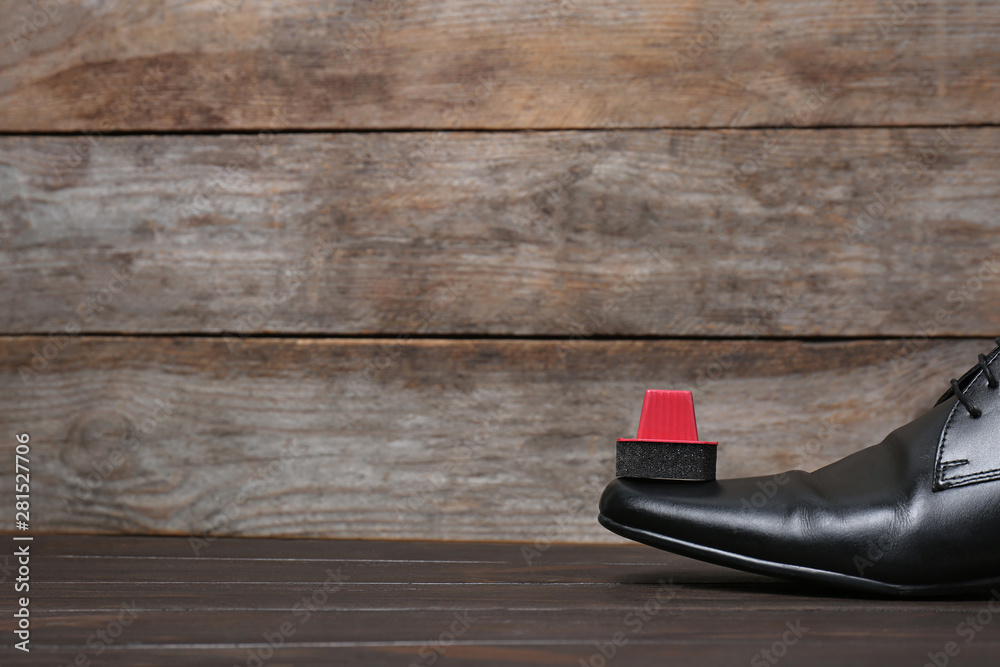 Men's leather shoes and cleaning sponge on wooden table, space for text Men's leather shoes and cleaning sponge on wooden table, space for text