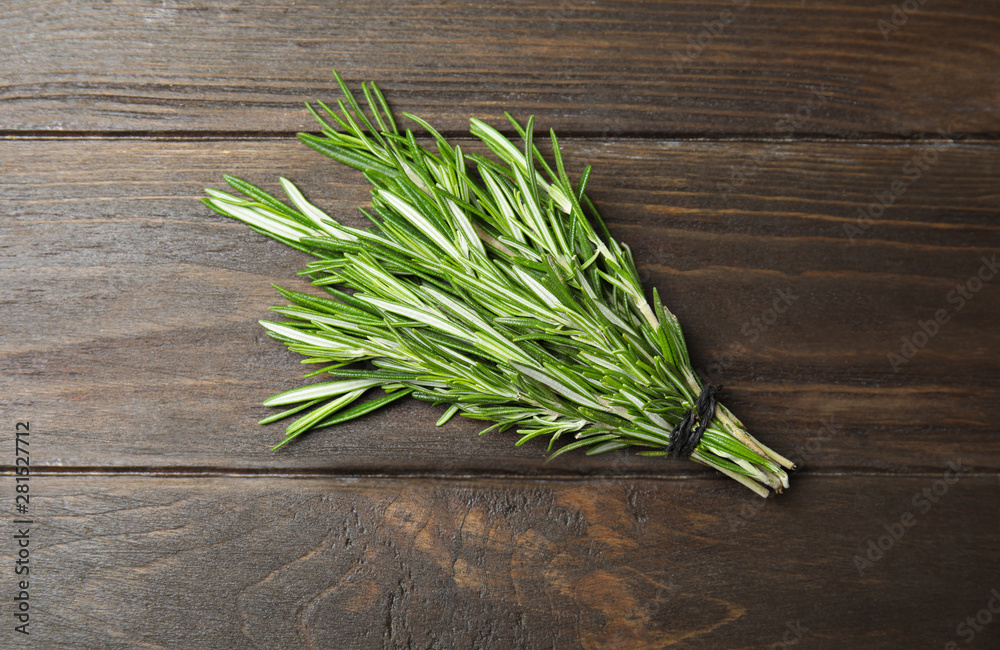 Bunch of fresh rosemary on wooden table, top view Bunch of fresh rosemary on wooden table, top view